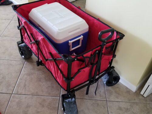 Red collapsible wagon with a white and blue cooler, symbolizing the beach-ready amenities offered at Marco Apollo 1001.