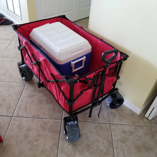 Red collapsible wagon with a white and blue cooler, symbolizing the beach-ready amenities offered at Marco Apollo 1001.