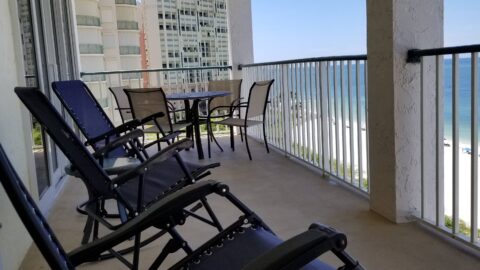 Panoramic view from the balcony at Marco Apollo 1001, featuring ample seating and stunning views of the beach and ocean.