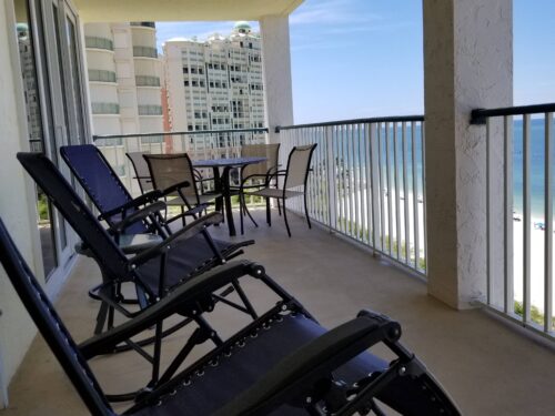 Panoramic view from the balcony at Marco Apollo 1001, featuring ample seating and stunning views of the beach and ocean.