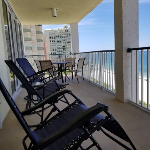 Panoramic view from the balcony at Marco Apollo 1001, featuring ample seating and stunning views of the beach and ocean.