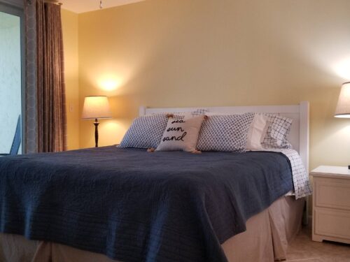 Cozy bedroom with a nautical theme, complete with sailboat artwork and plush bedding at Marco Apollo 1001 condo rental.