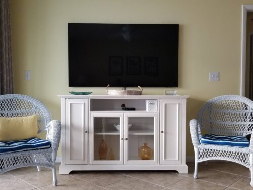 Inviting living room with comfortable wicker chairs and large TV, perfect for entertainment and relaxation at Marco Apollo 1001.